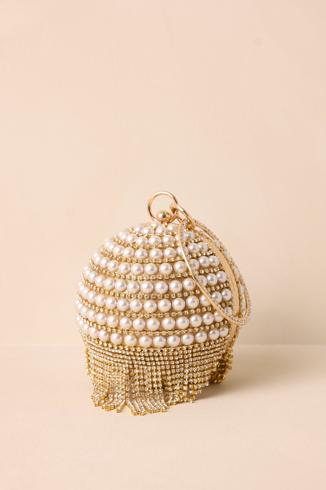 Another zoomed-in shot of the clutch, showcasing the elegant dangling diamond accents and luxurious gold hardware.