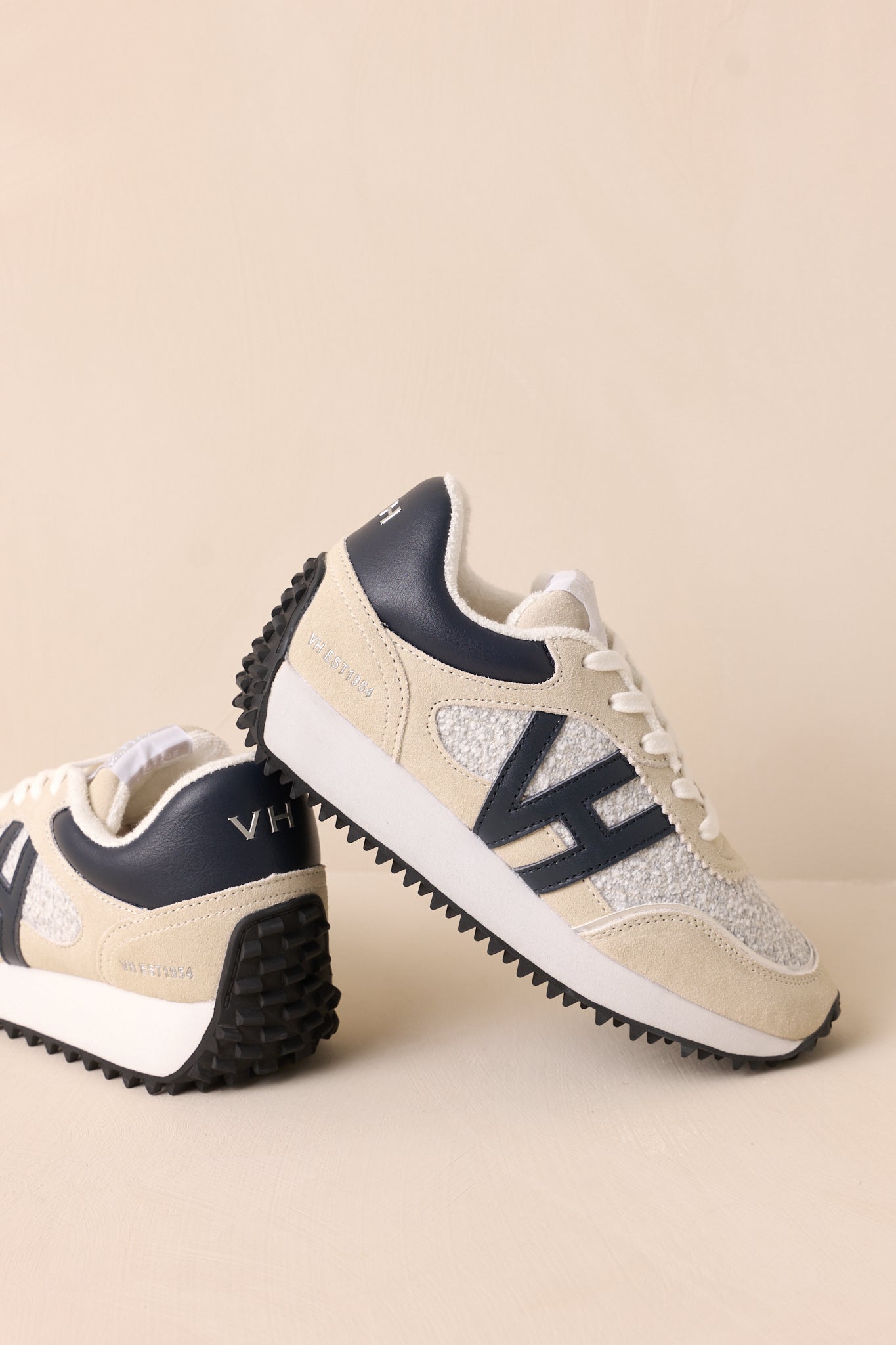 The sneakers positioned side-by-side against a beige background, highlighting their matching design and cohesive color scheme.