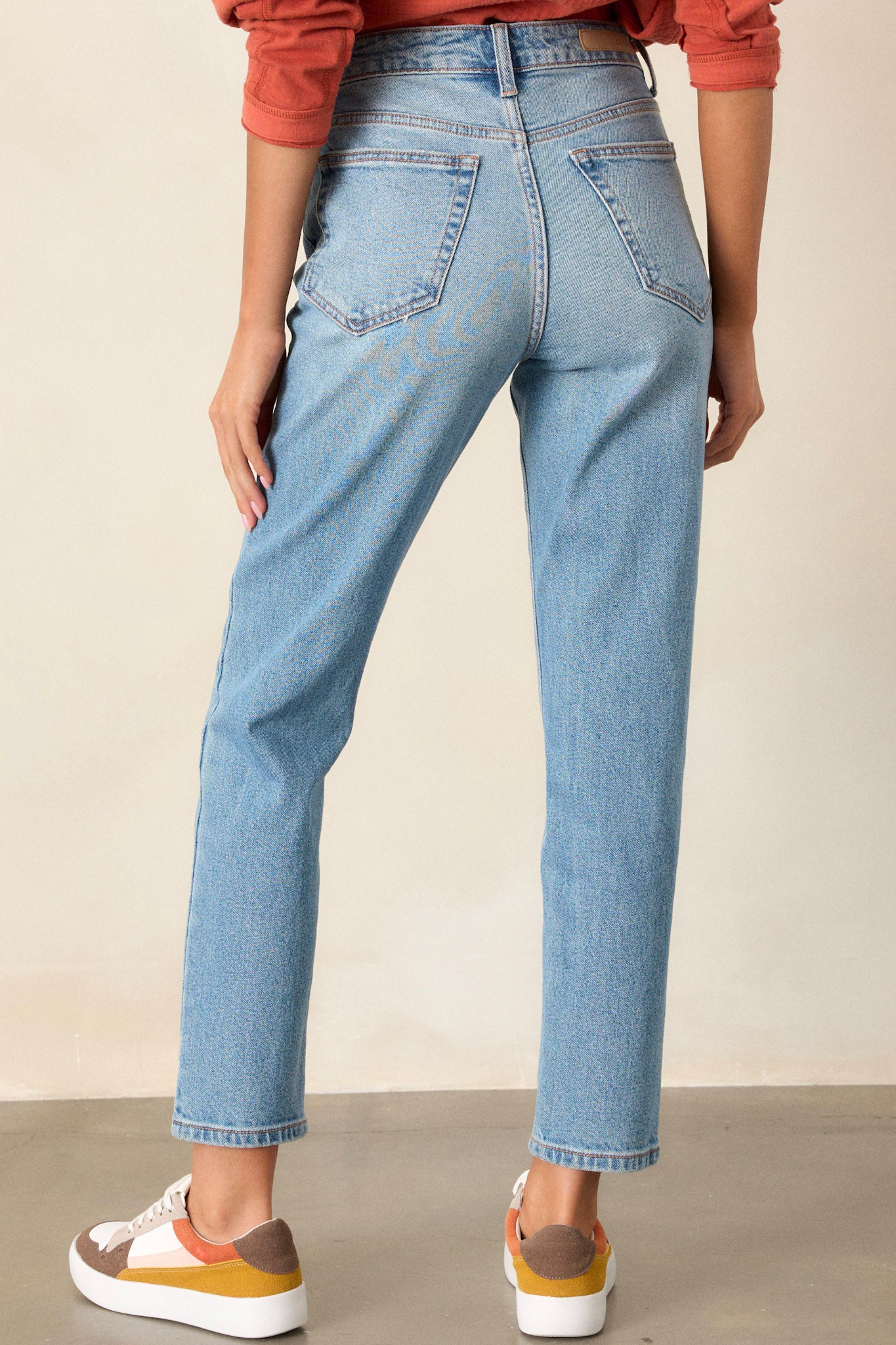 Back view of these medium wash straight leg jeans featuring 5-pocket detailing and a standard zipper and button closure.