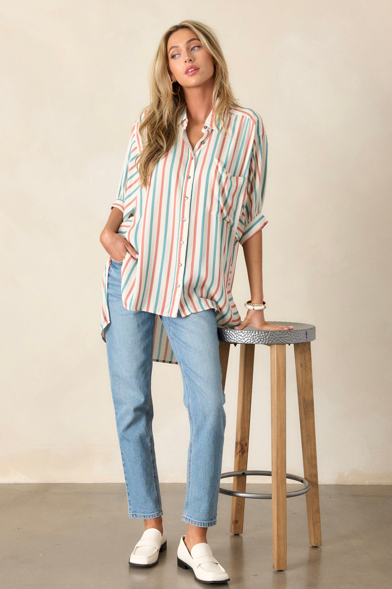 This top features a collared neckline, a functional button-front, and cuffed short sleeves.