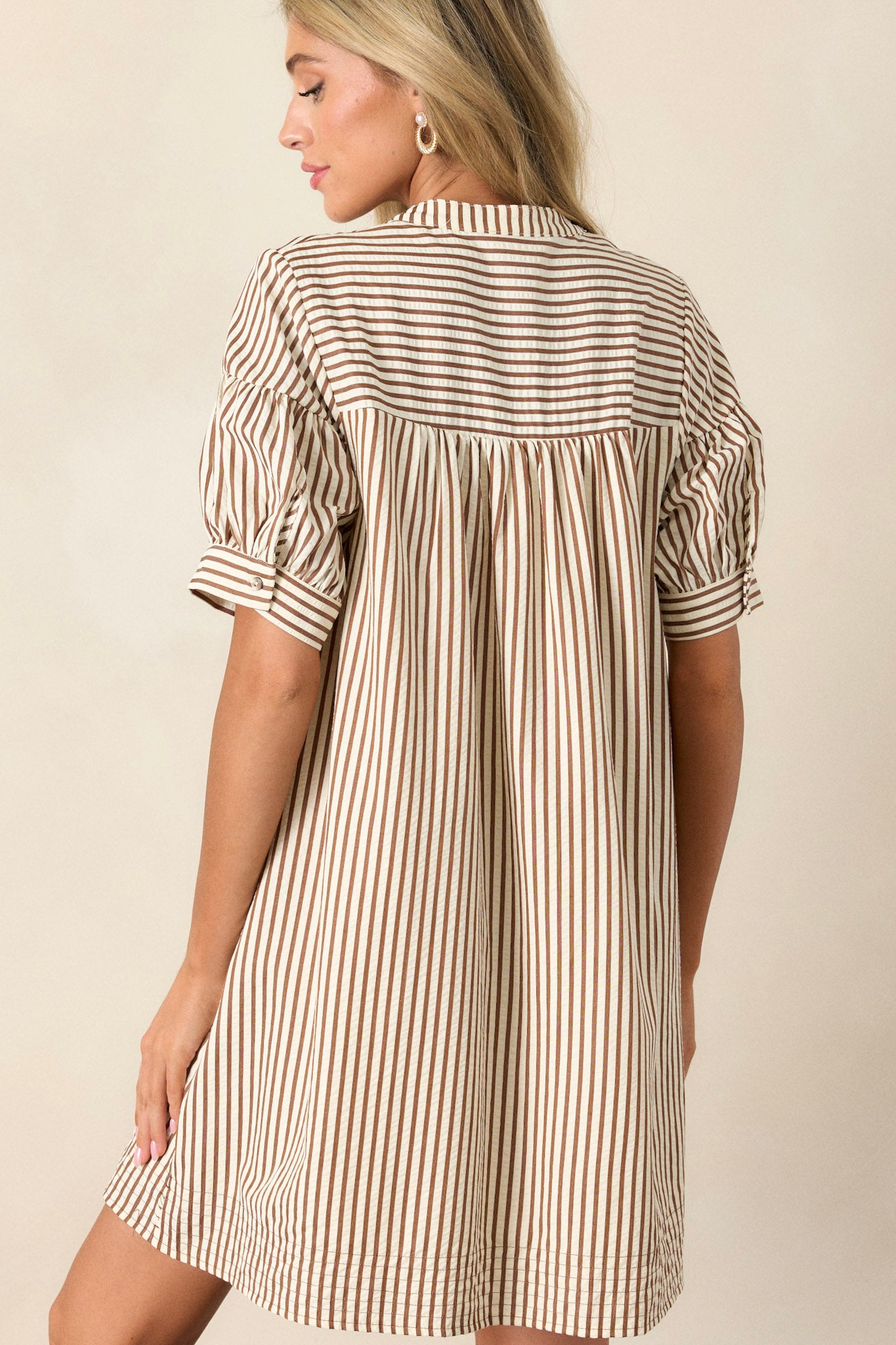 Back view of a brown stripe dress highlighting the vertical brown and white stripe design, relaxed fit, and short sleeves