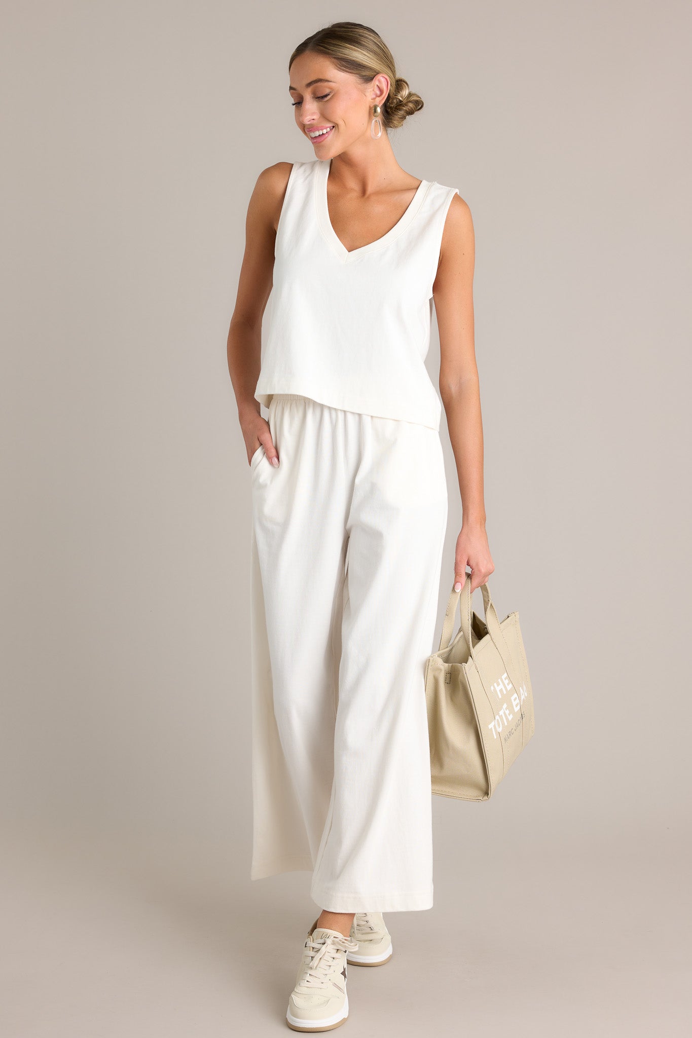 Action shot of a white tank displaying the fit and movement, highlighting the v-neckline, sleeveless design, and slightly cropped hemline.