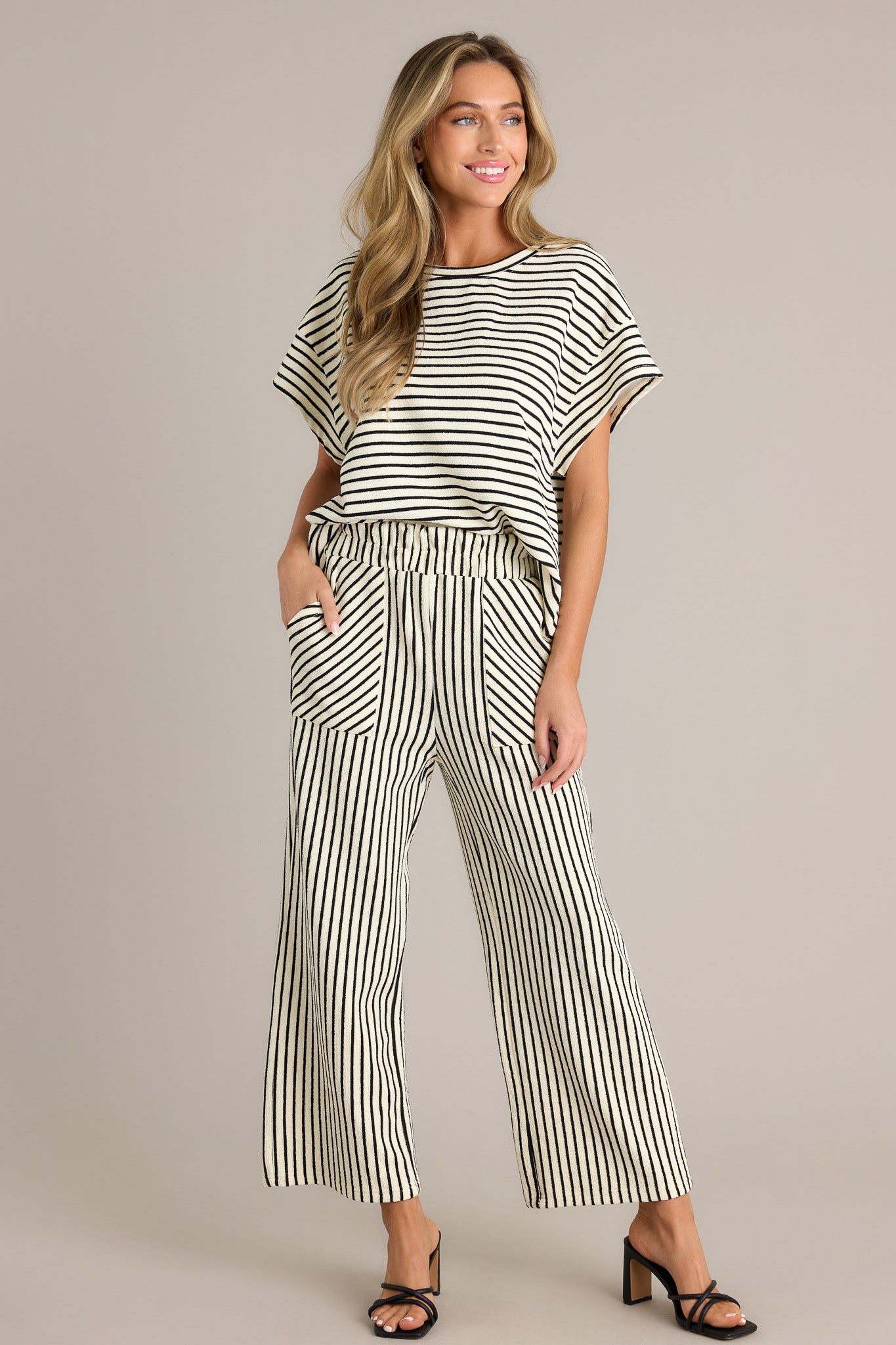 These black stripe pants feature a high waisted design, a elastic waistband, a self-tie drawstring, functional hip pockets, and a wide leg