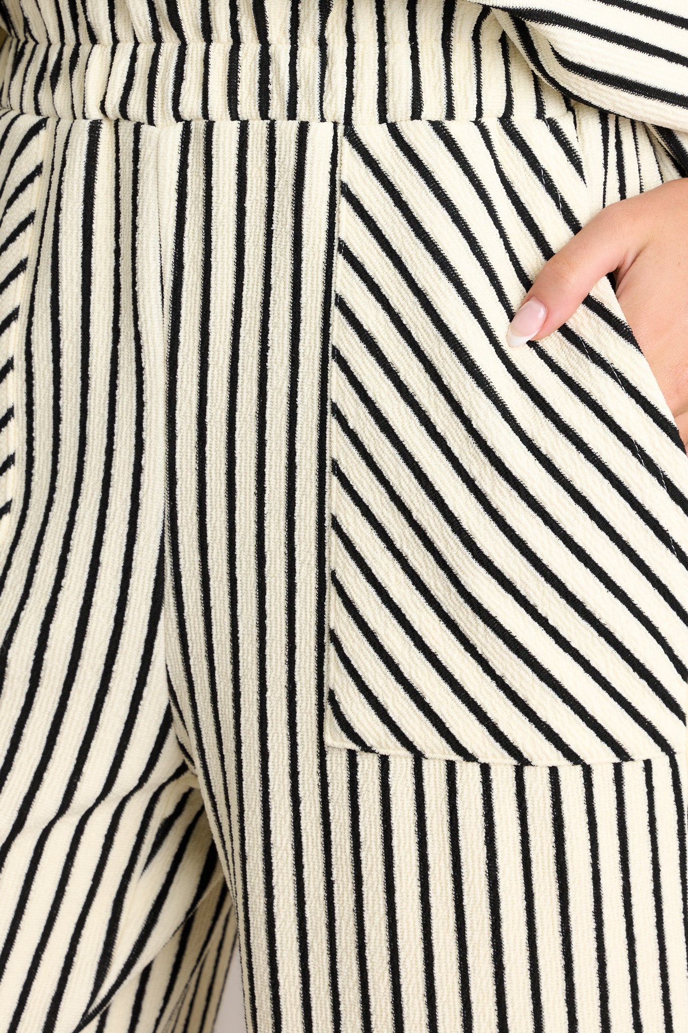 Close-up of the black stripe pants showing the high waisted design, self-tie drawstring, and functional hip pockets.