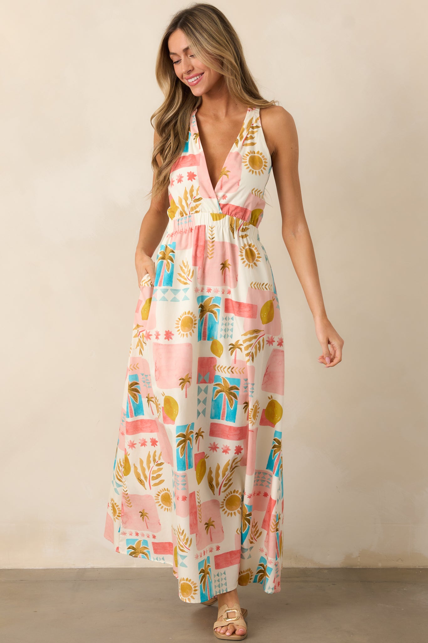 The pink dress shown from the front, highlighting its tropical print, v-neckline, and the relaxed flow of the skirt with elastic shoulder straps.