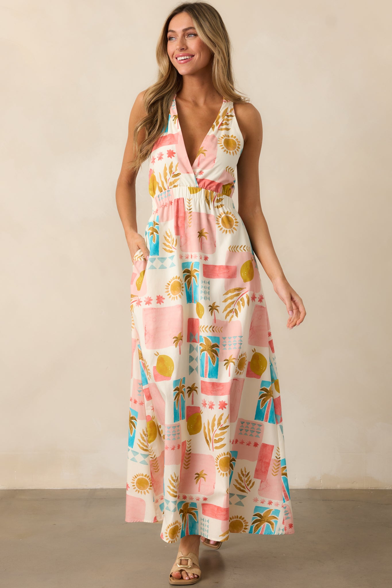 The dress from a front-facing view, emphasizing the criss-cross back detailing, elastic shoulder straps, and the tropical print design.