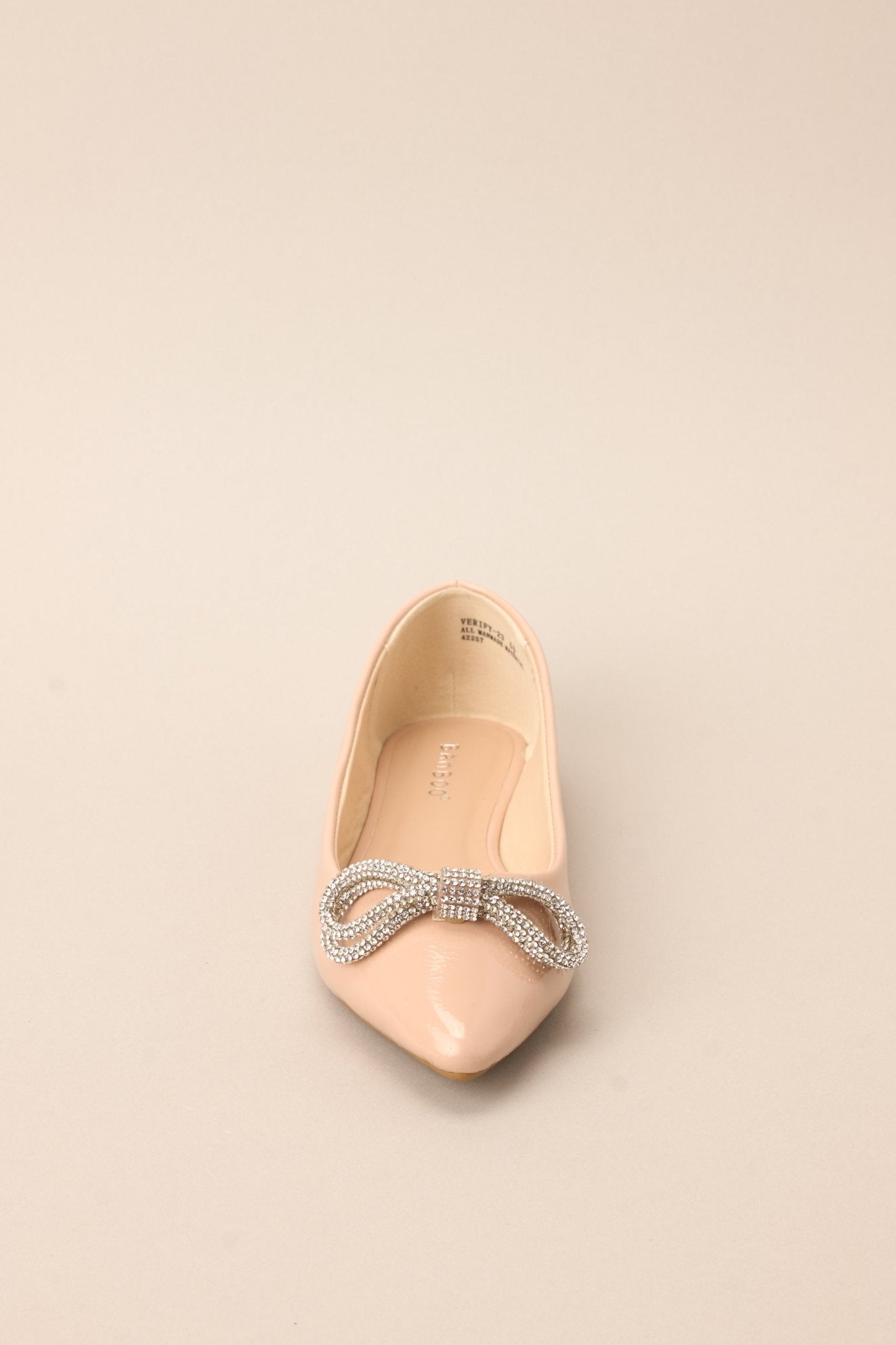 Front view of these chic flats with a pointed toe, adorned with a dazzling rhinestone-embellished bow, and finished with a shiny sheen.