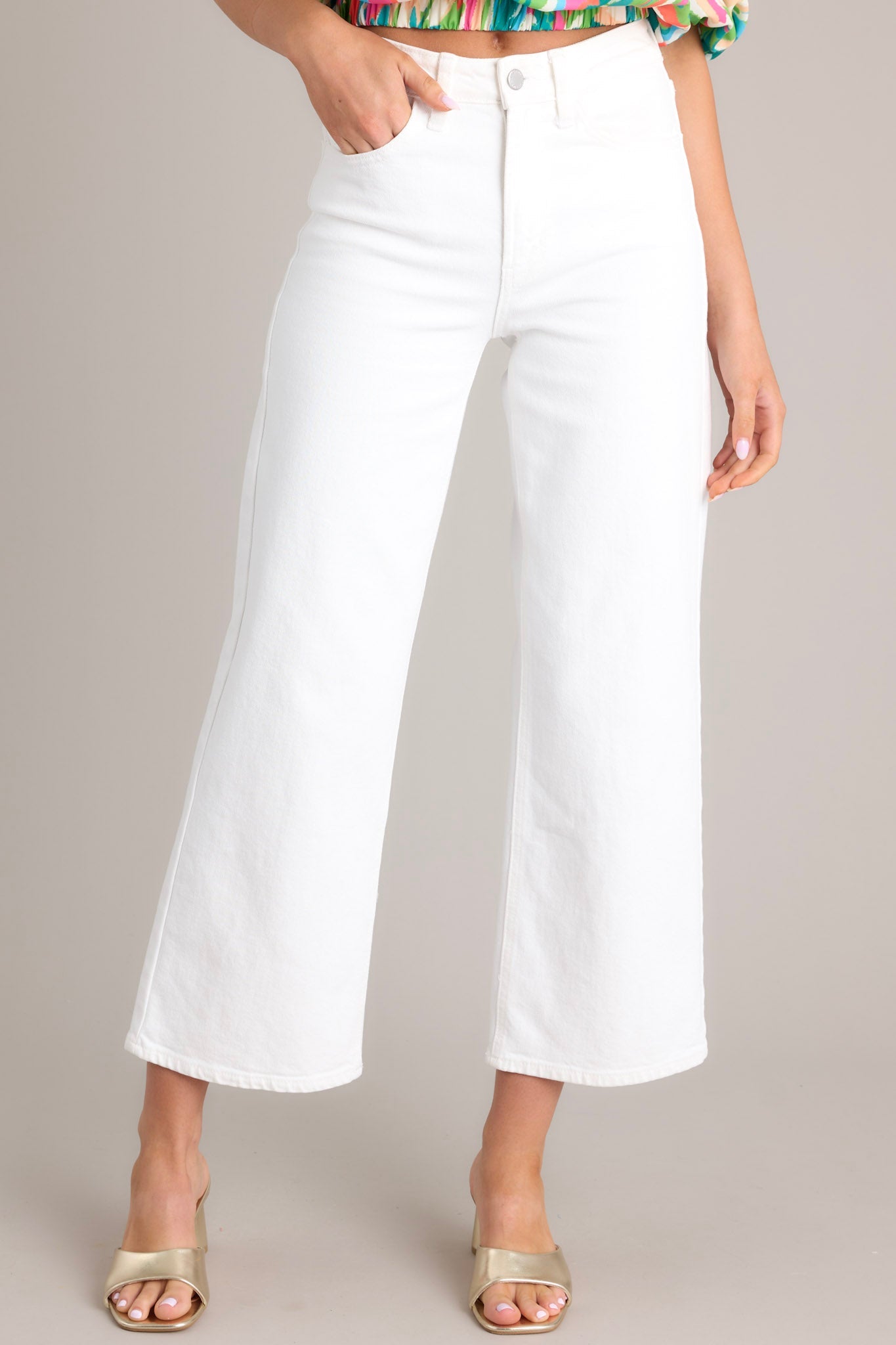 Front view of these white jeans that feature a high waisted design, classic button & zipper closure, belt loops, functional front & back pockets, and a cropped length.