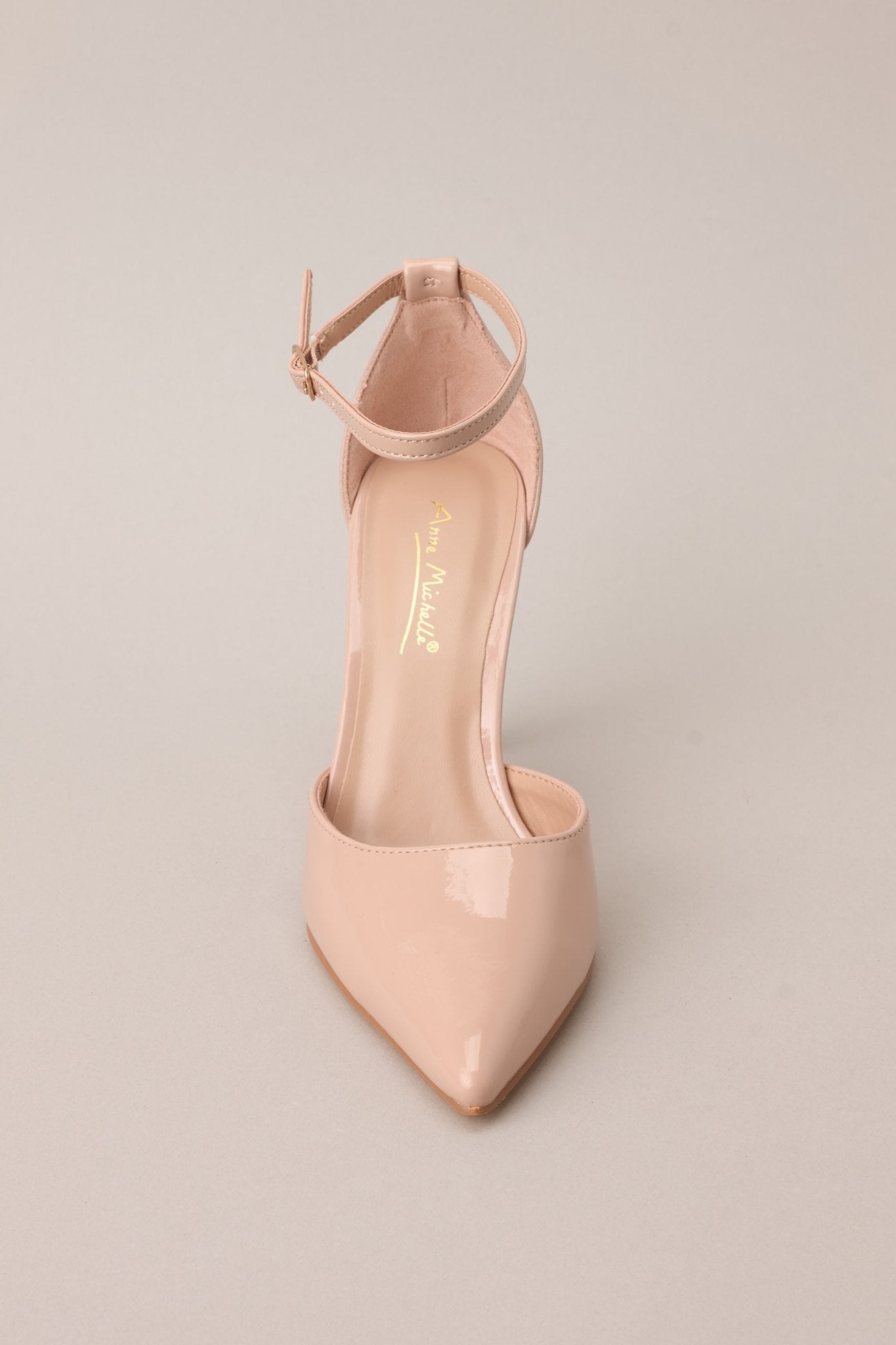 A top-down view showcasing the pointed toe design and sleek beige nude material.