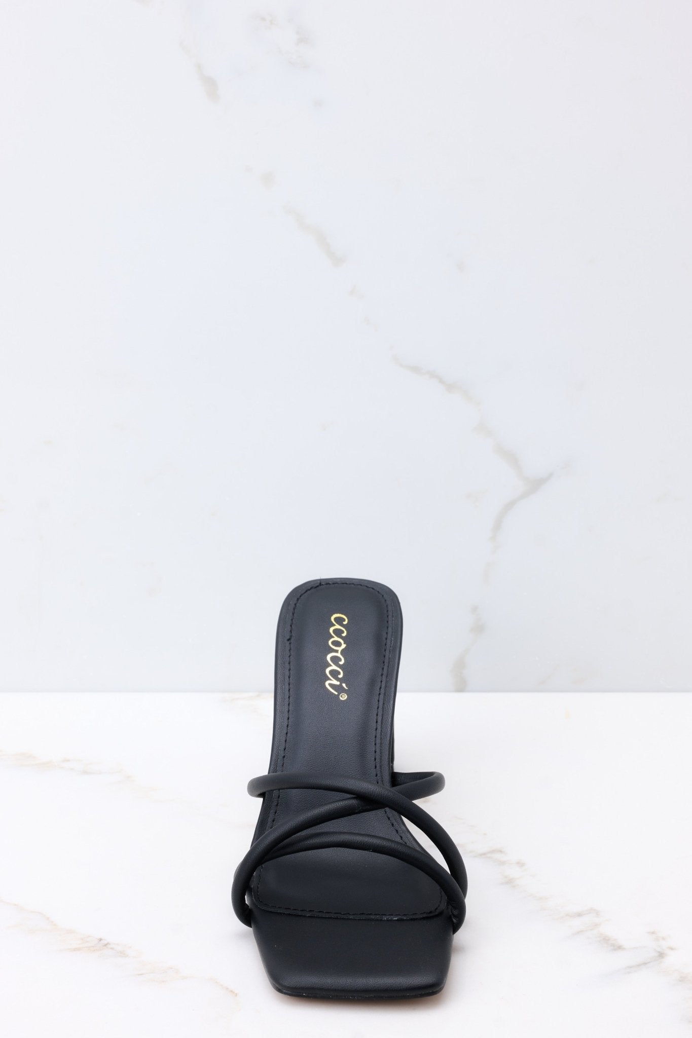 Front view of these sandals that feature a textured black finish, three straps across the top of the foot, a flattened block heel, and light cushioning in the base.